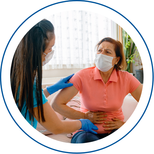 Photo of a healthcare professional helping a patient who is holding her stomach